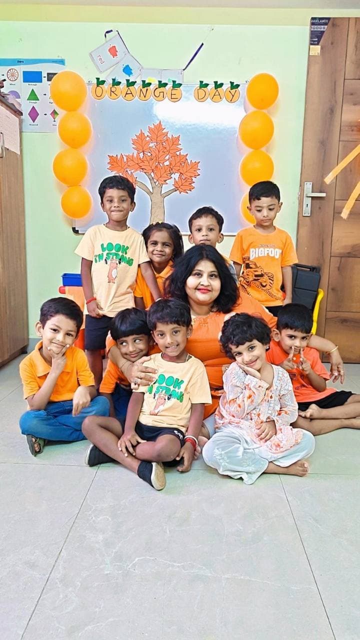 Children and their teacher dressed in orange for Color Day