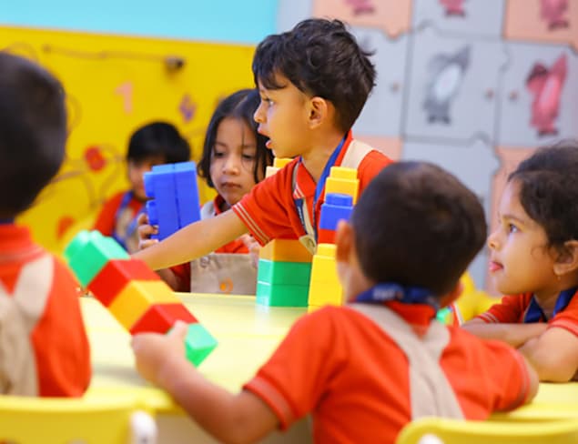 Children exploring toys and building blocks in a playroom